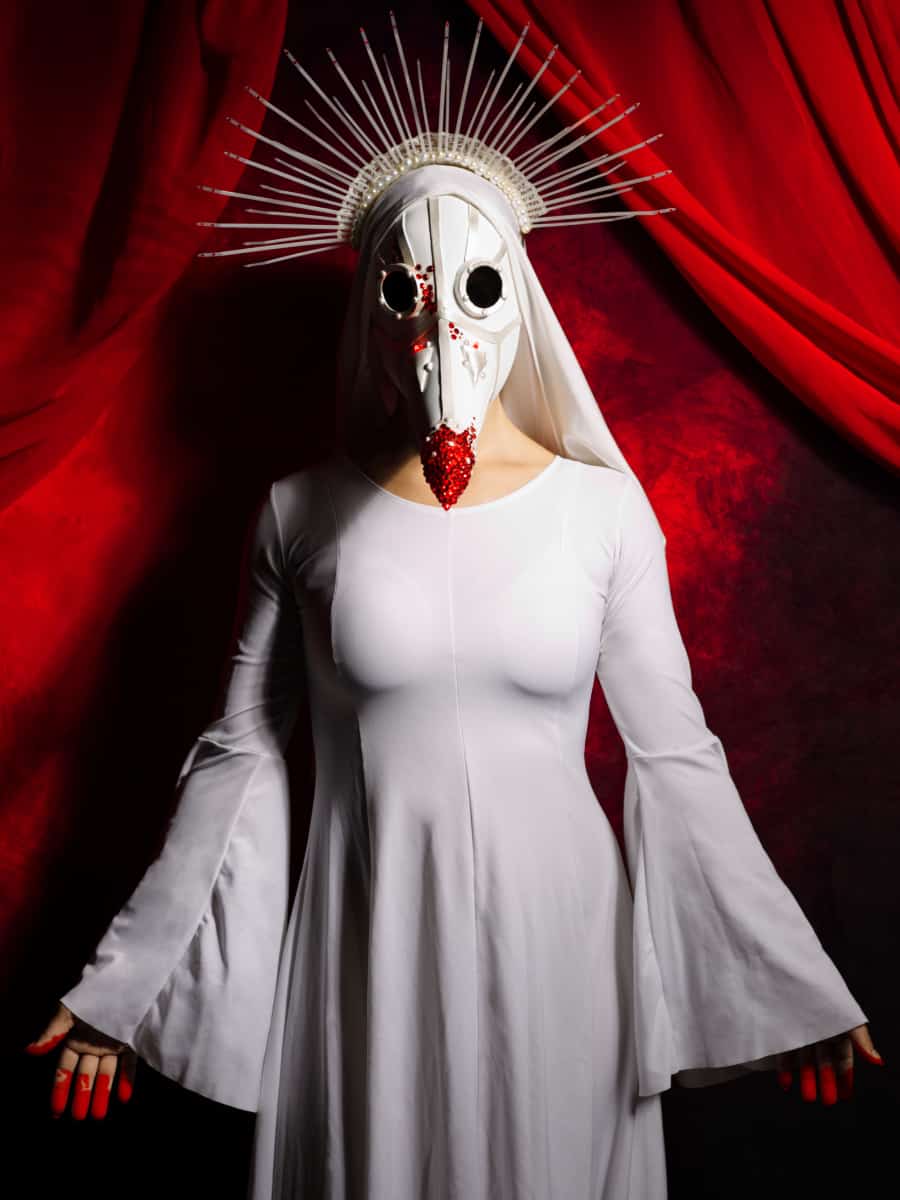 Blood red crystal adorn the white plague doctor mask Jana is wearing in this Gothesque editorial