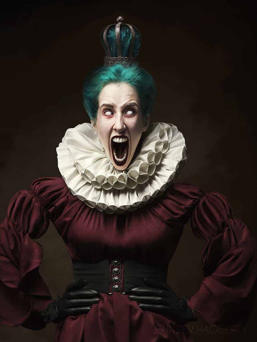 Jennifer is the burgundy Queen with an iron crown, teal hair, her eyes white out and her mouth is elongated and opened wide. She is wearing a burgundy dress, black waist belt and gloves, and a white Victorian collar.